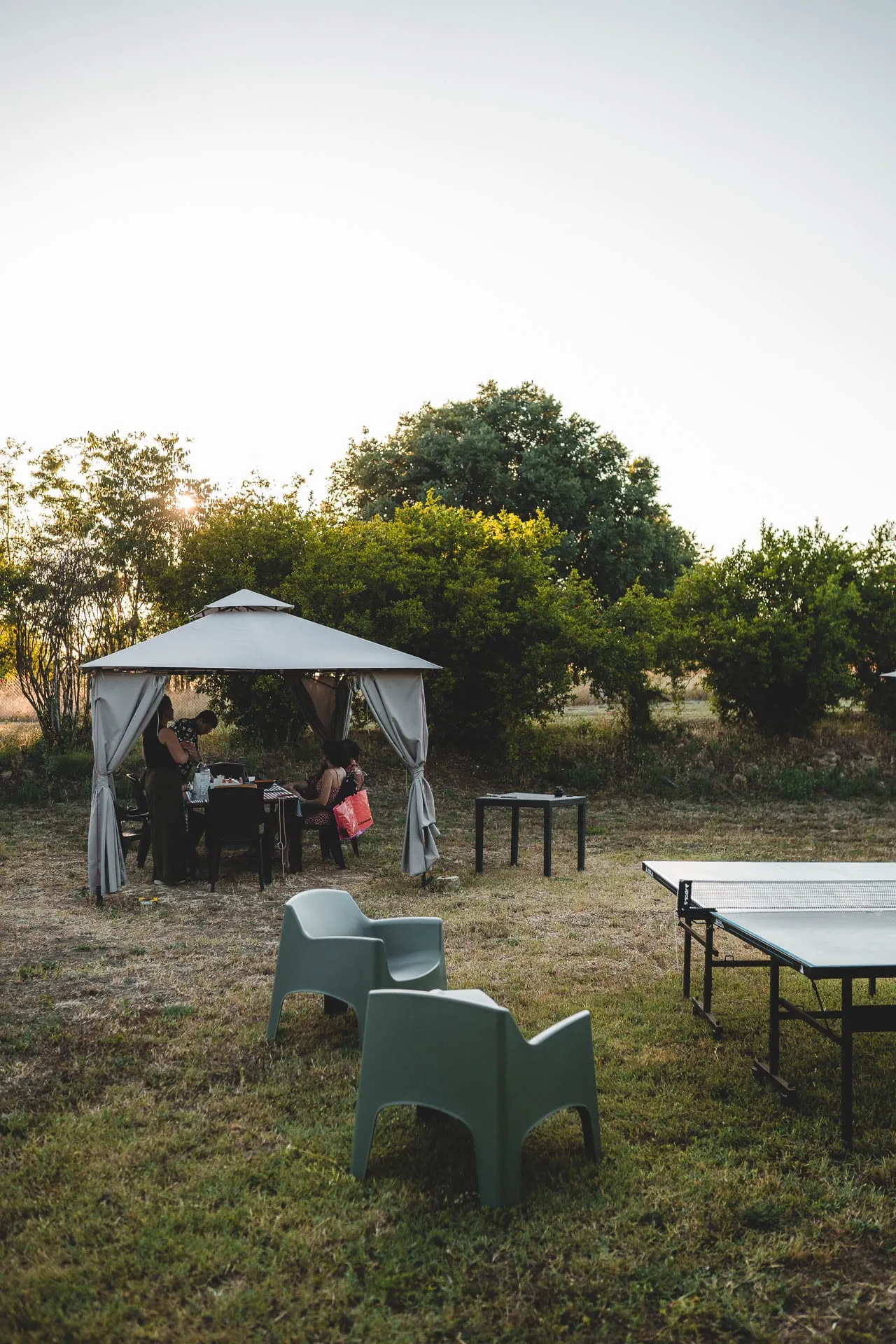 Il gazebo del giardino con poltroncine e tavolo da ping pong, di giorno