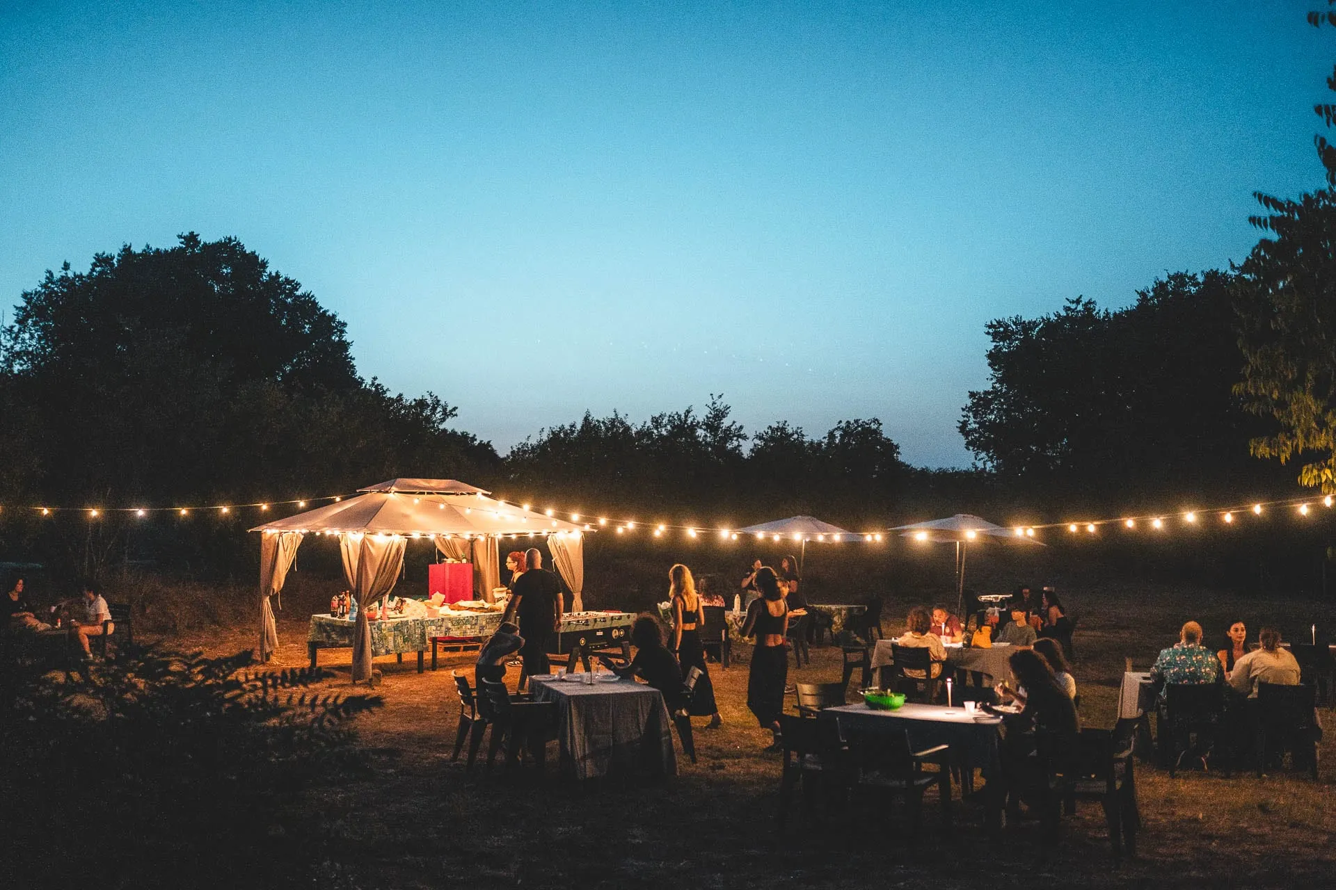 Ospiti a cena di sera sotto il gazebo e le luci