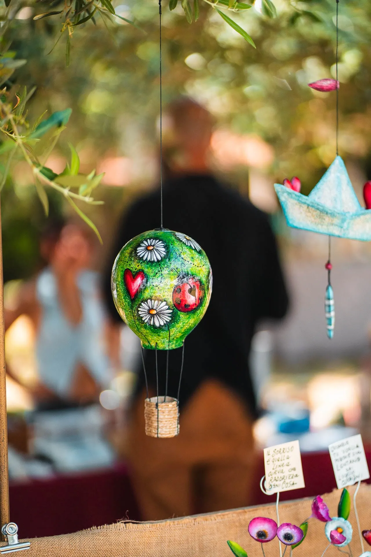 A decorative hot-air balloon hanging from olive branches