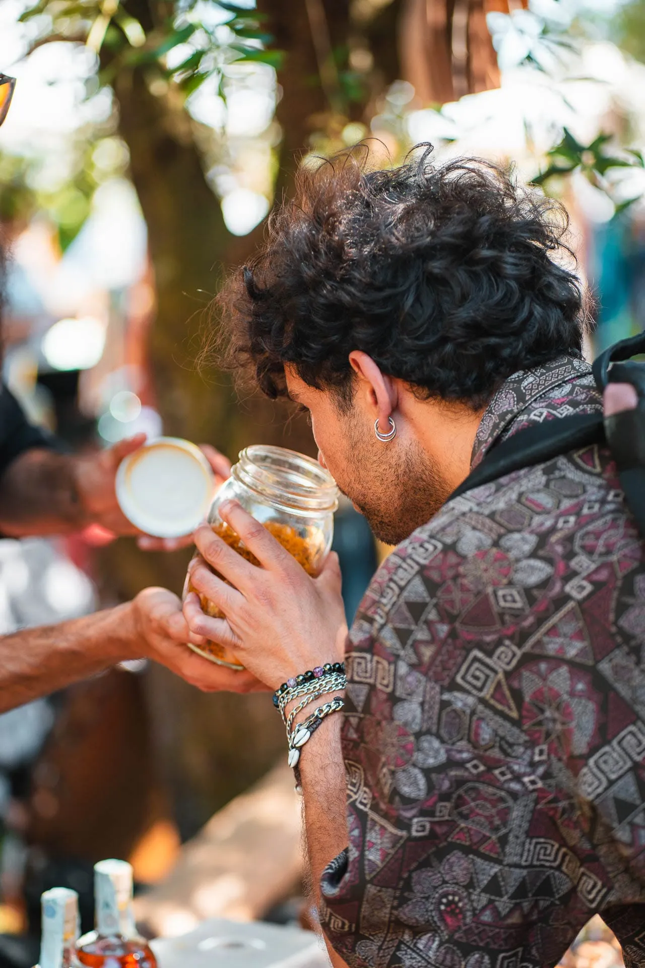A visitor smells a jar at a stall