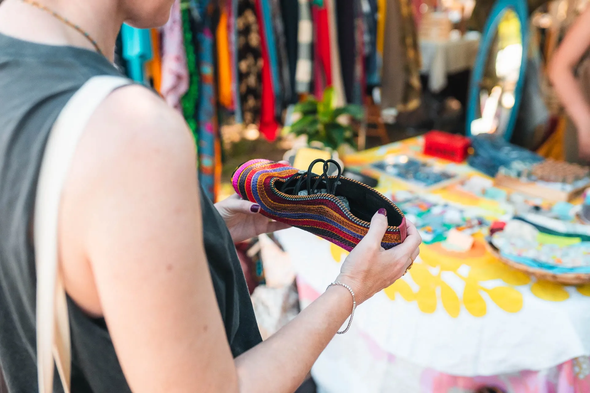 A visitor looks at a colourful piece at a textile stall