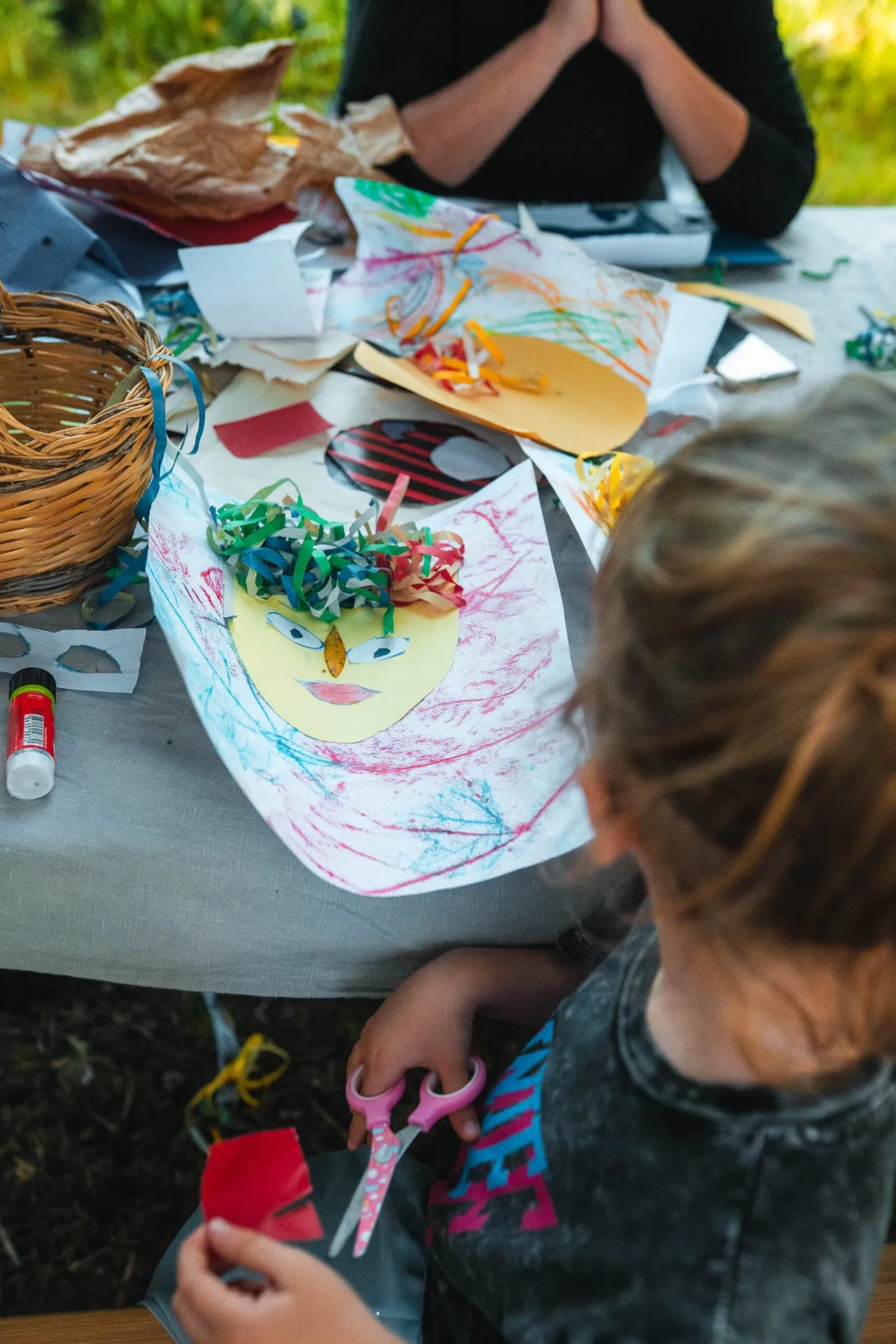 A child at a creative workshop with paper and colours