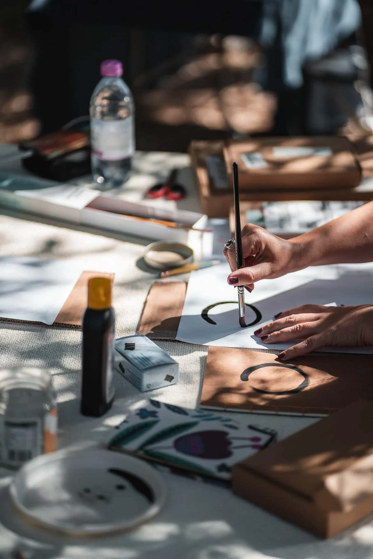 A hand painting with a brush during a workshop