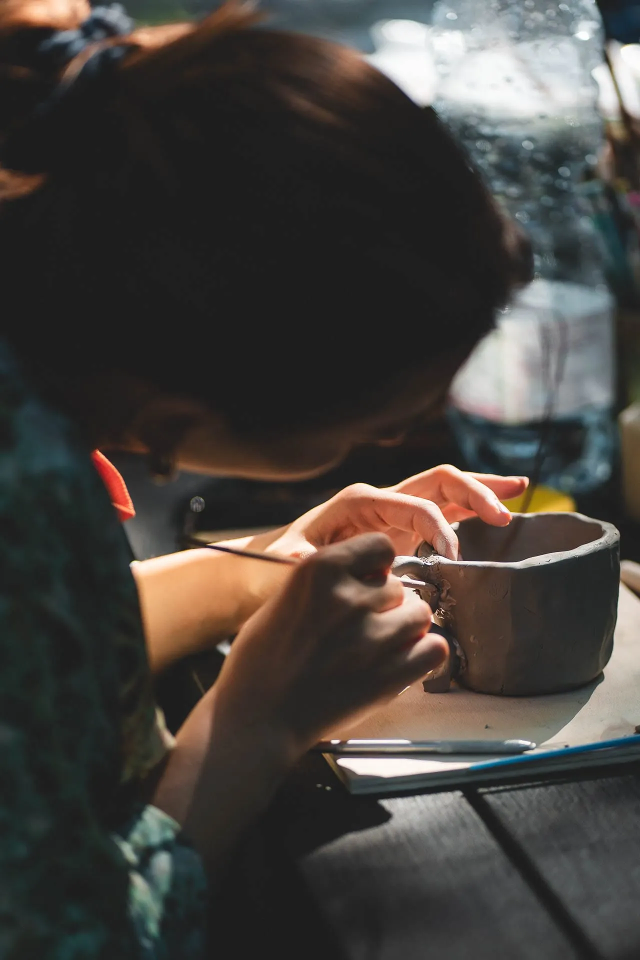 Una partecipante modella un vasetto d'argilla durante un workshop